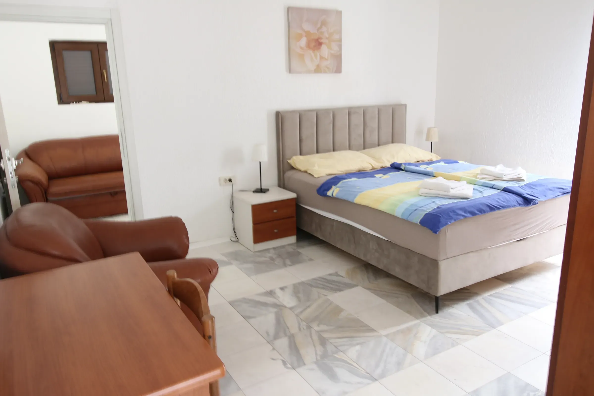 Double bedroom with a leather reading chair by the window