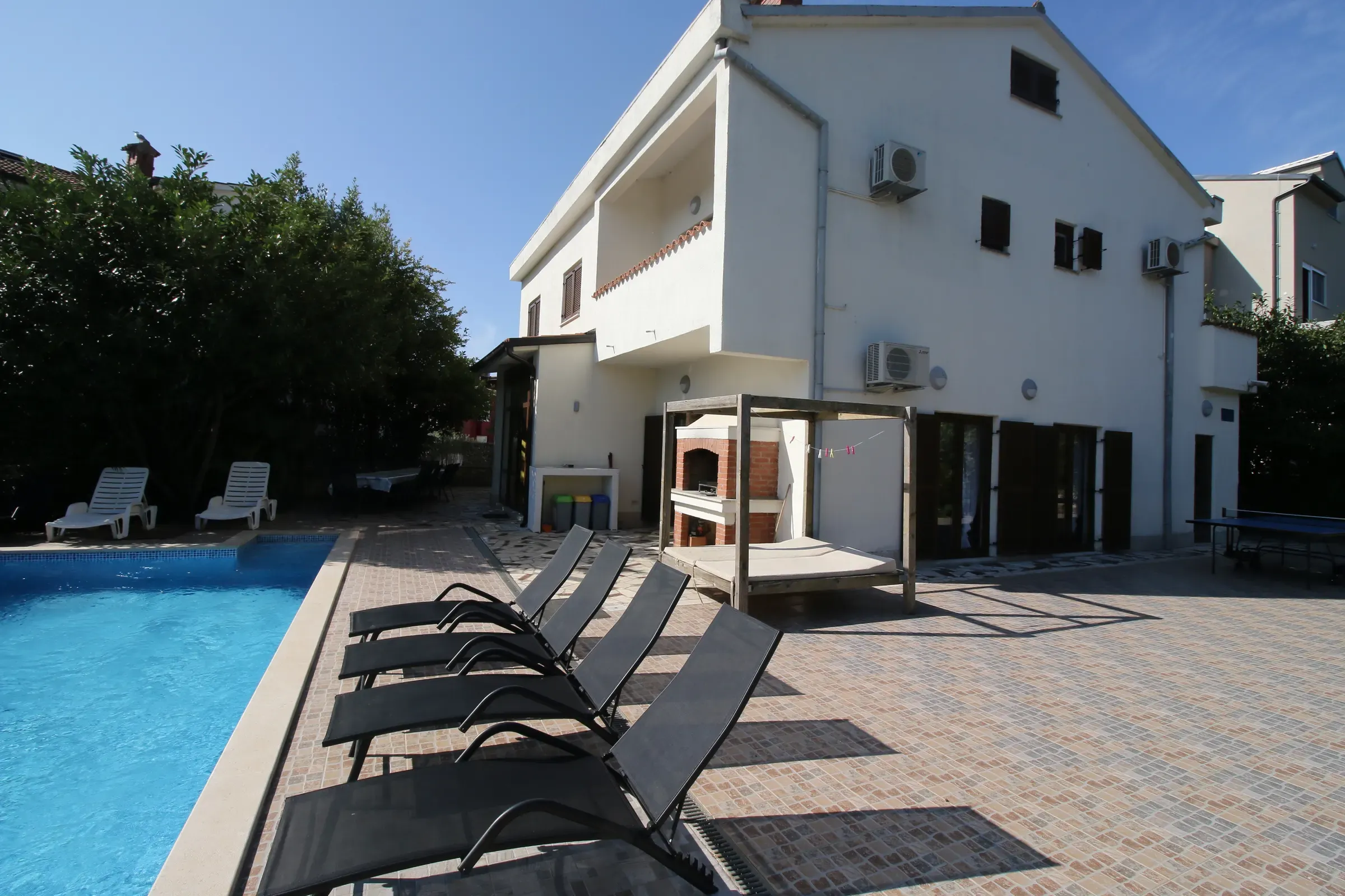 Poolside daybed and sun loungers beside Villa Eucalyptus