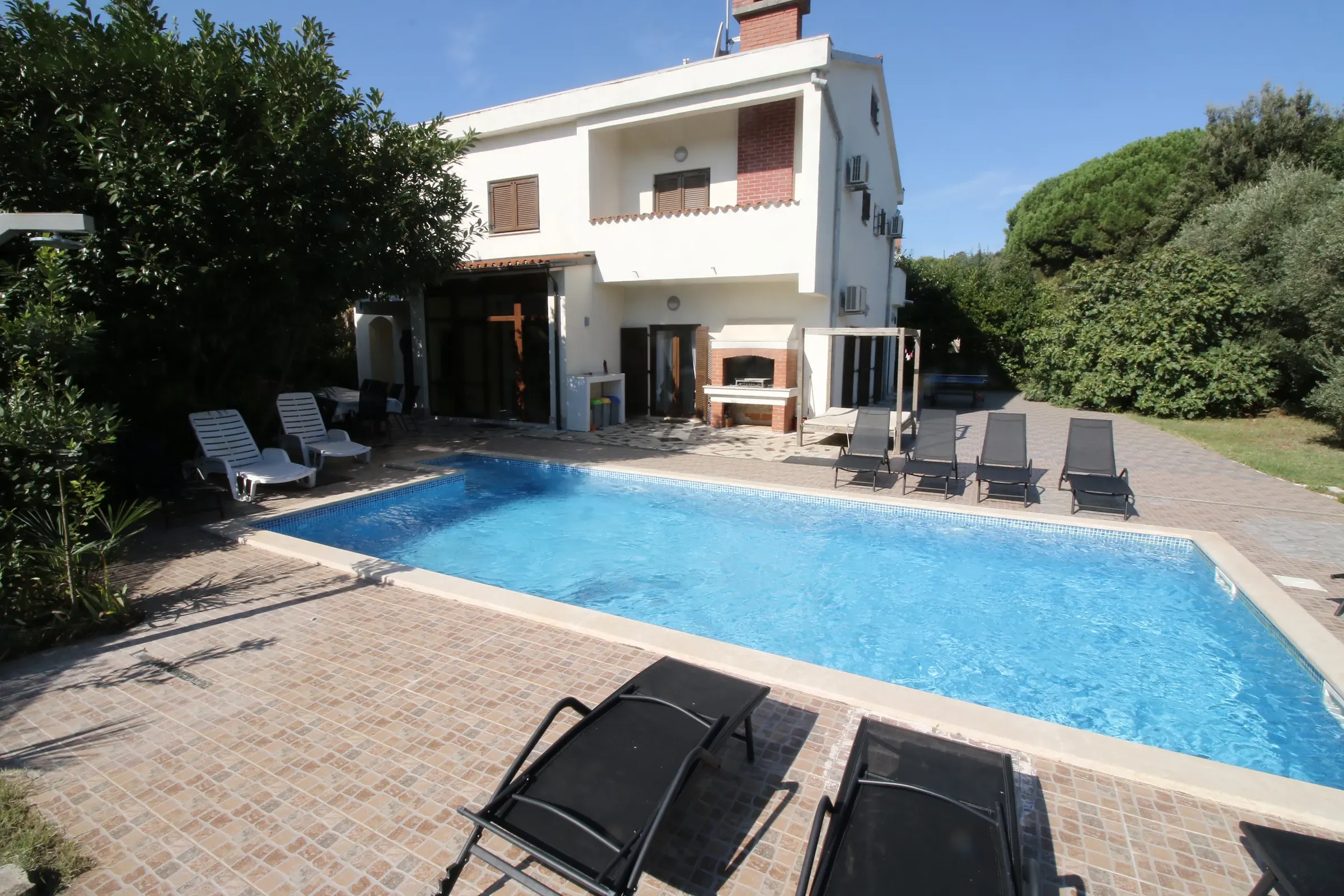 Rows of sun loungers along the private pool of Villa Eucalyptus