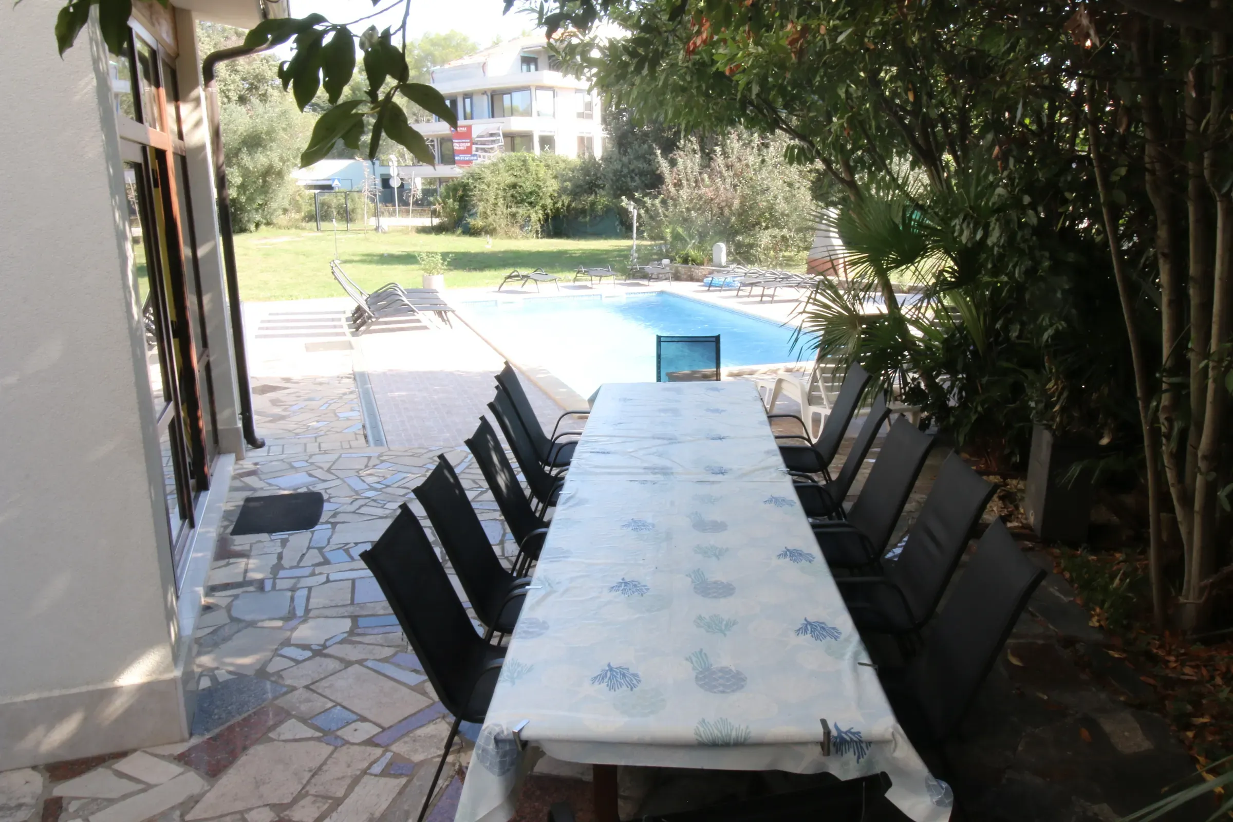 Long covered dining table on the terrace, set for the whole group
