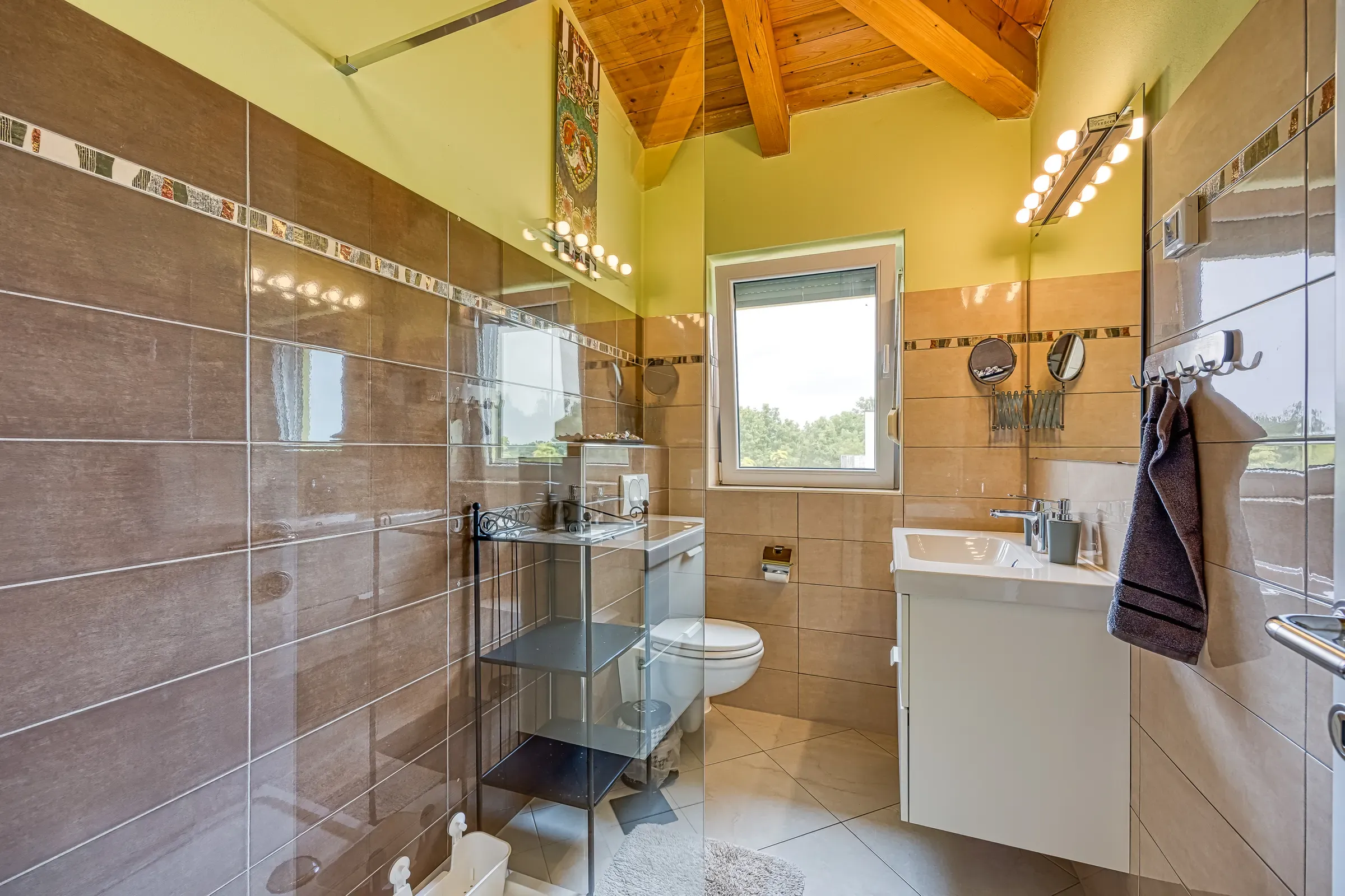 Bathroom with a vanity and shower beneath the attic window