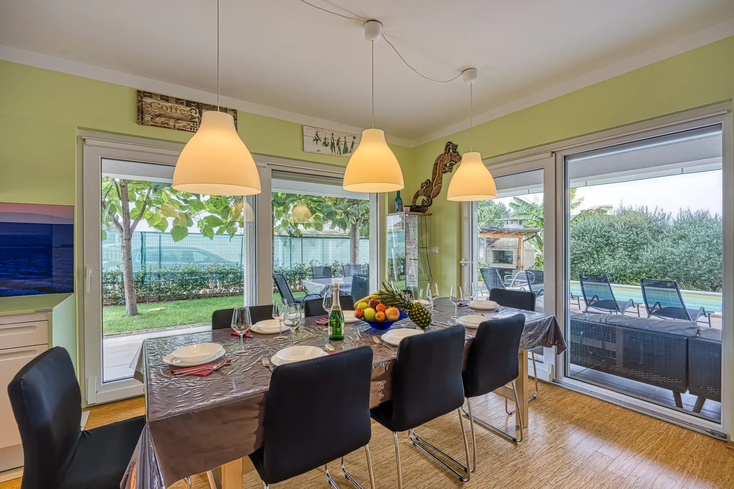 Dining table for eight beside floor-to-ceiling garden windows