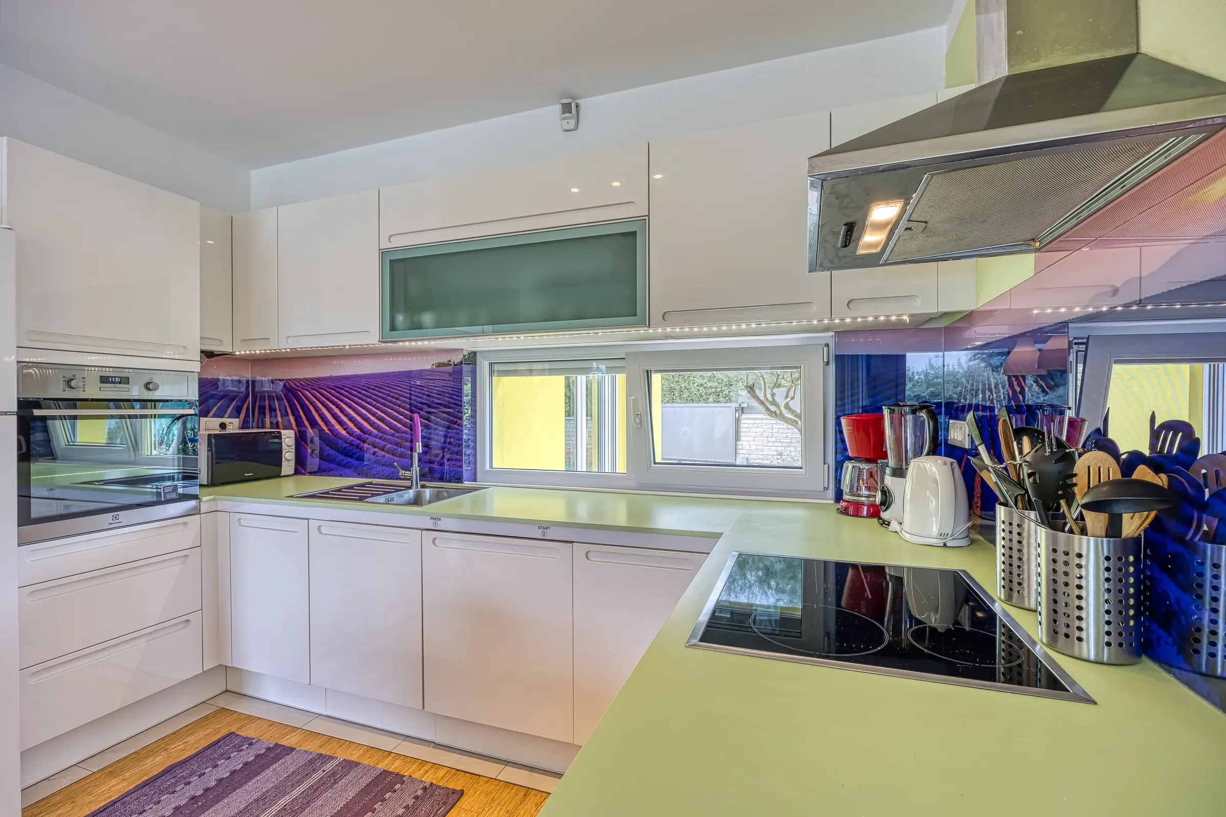 Modern kitchen with induction hob and lavender-field splashback